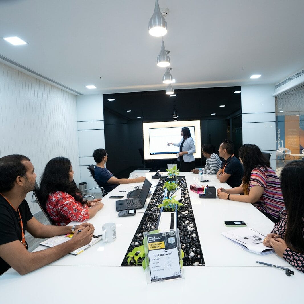 people sitting at the table looking to another person standing in front of them